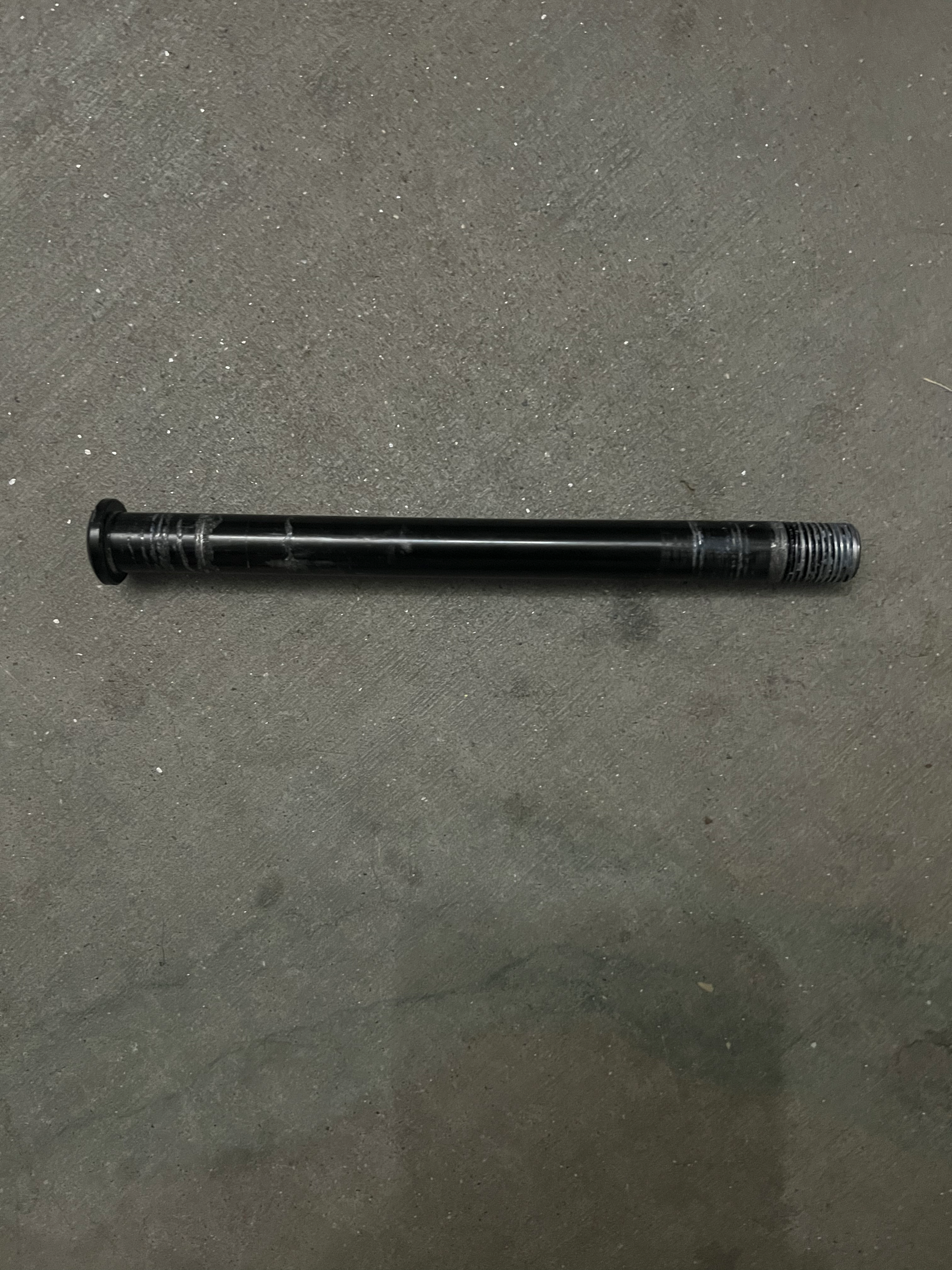 Front axle bolt and nut for GT73 on a concrete surface.